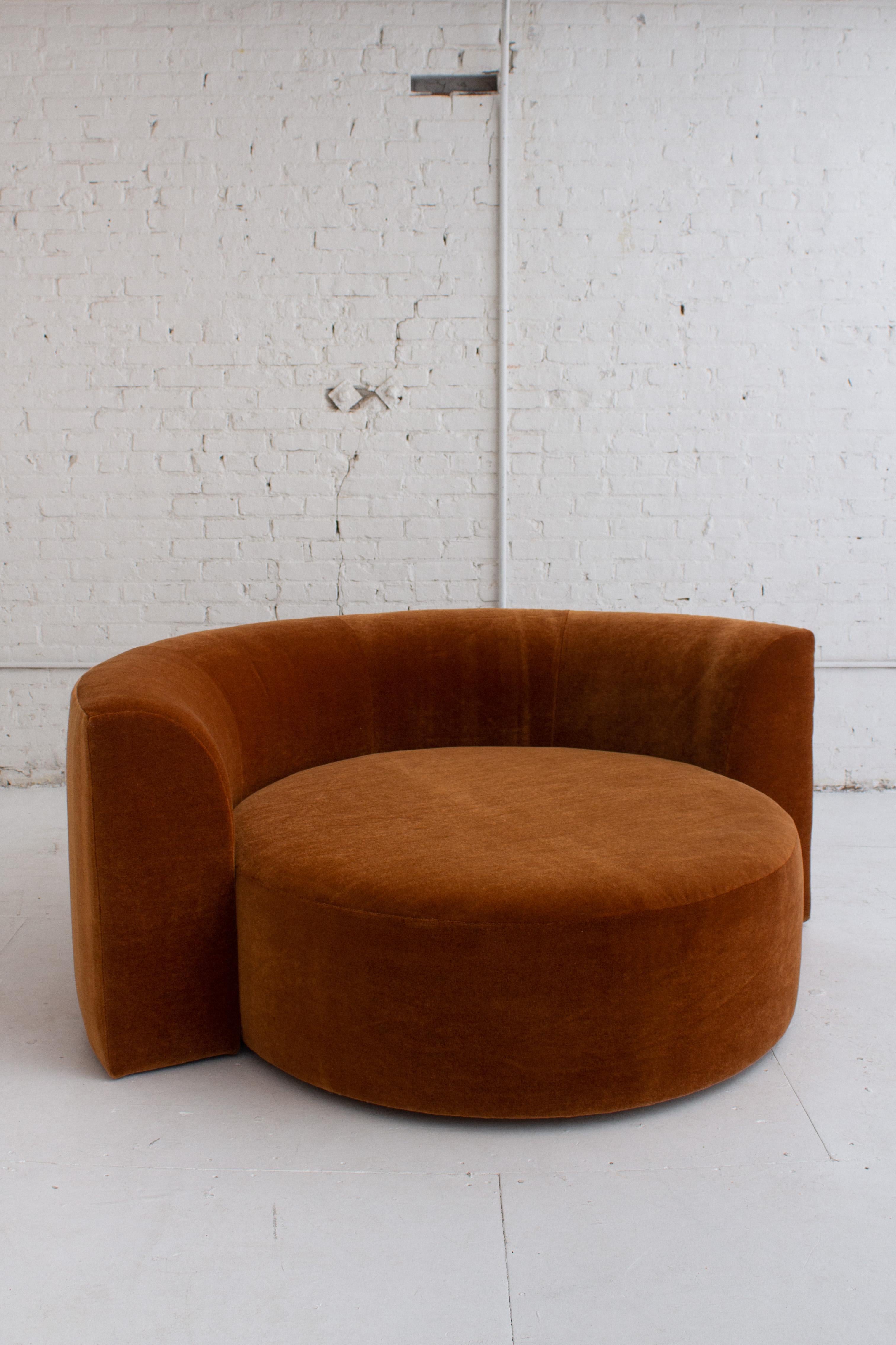 A circular chaise by Roger Rougier. Updated upholstery in a rust mohair. Movable back rest sits on wheels to rotate around center circle. Inner circle measures 47” in diameter by 16” high.