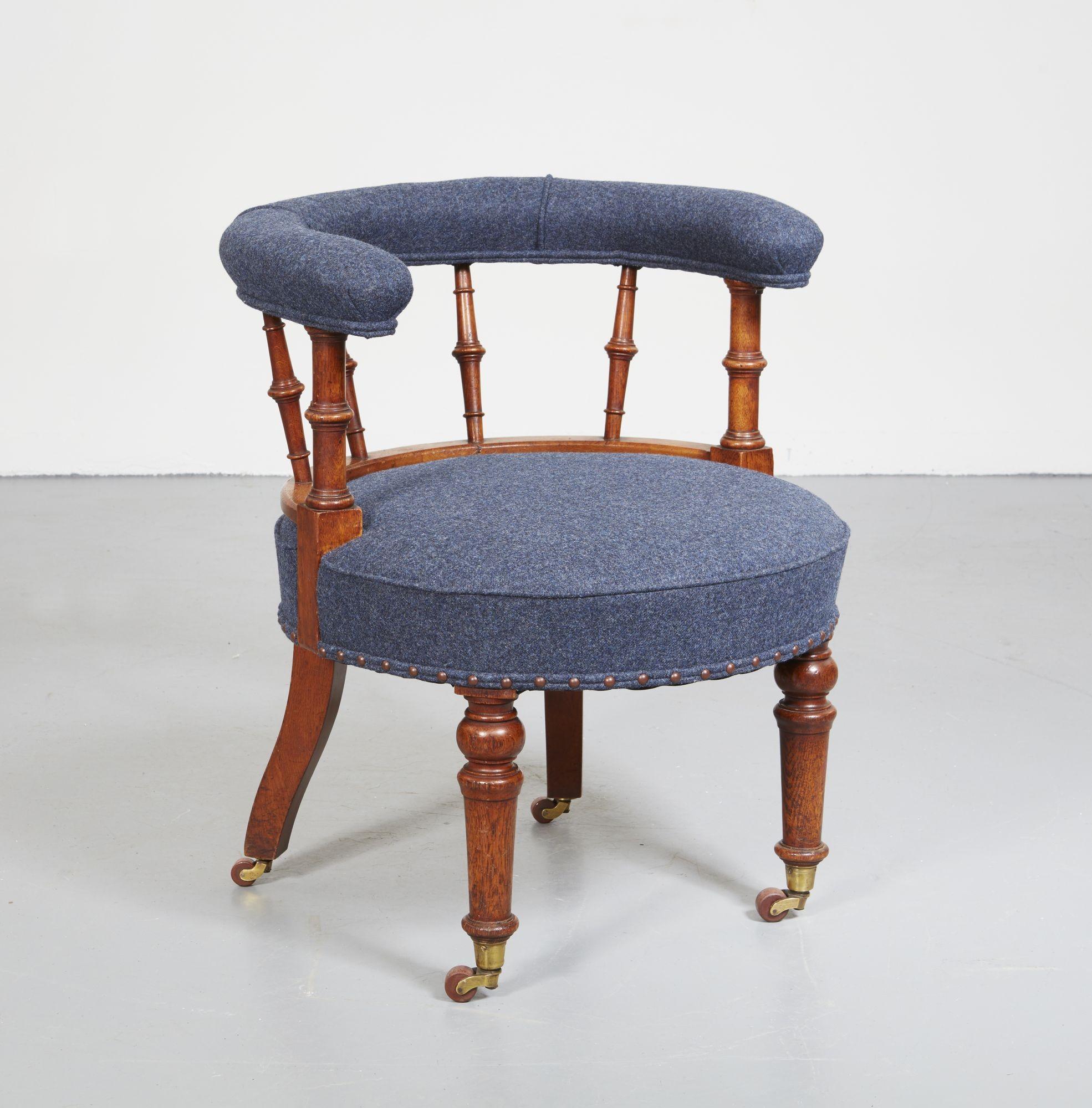 A 19th century Scottish country house circular chair with circular upholstered seat and curved upholstered back on turned spindle supports, with front turned legs and back sabre legs, on original brass castors. Upholstered in blue-grey wool. 