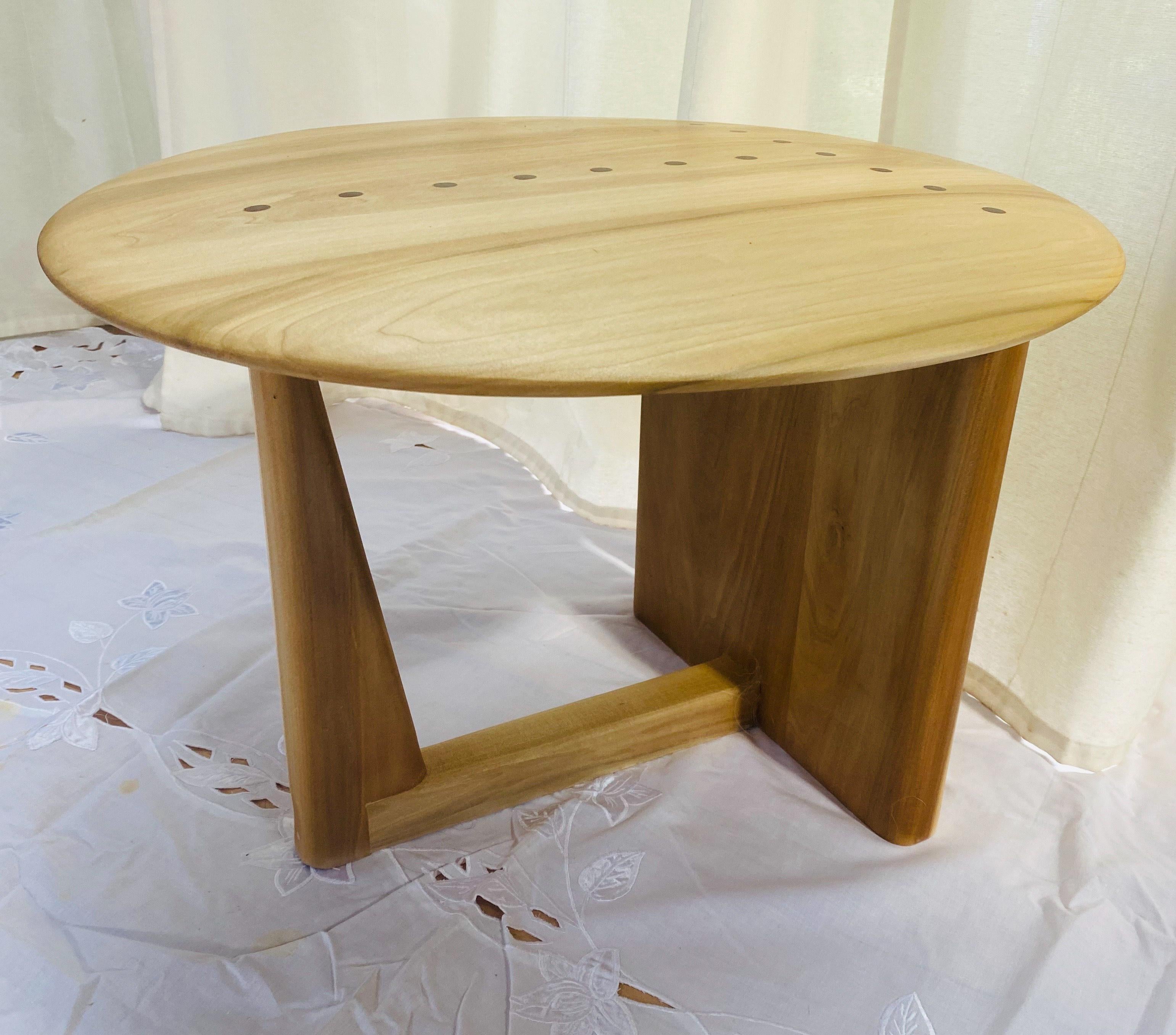End table disk. A modern design comprised of a perfect poplar disk with walnut pegs balanced on a 3-point base. Designed to be placed next to your favorite chair, in order to accomodate a glass of wine as you let the days tribulation drain away.