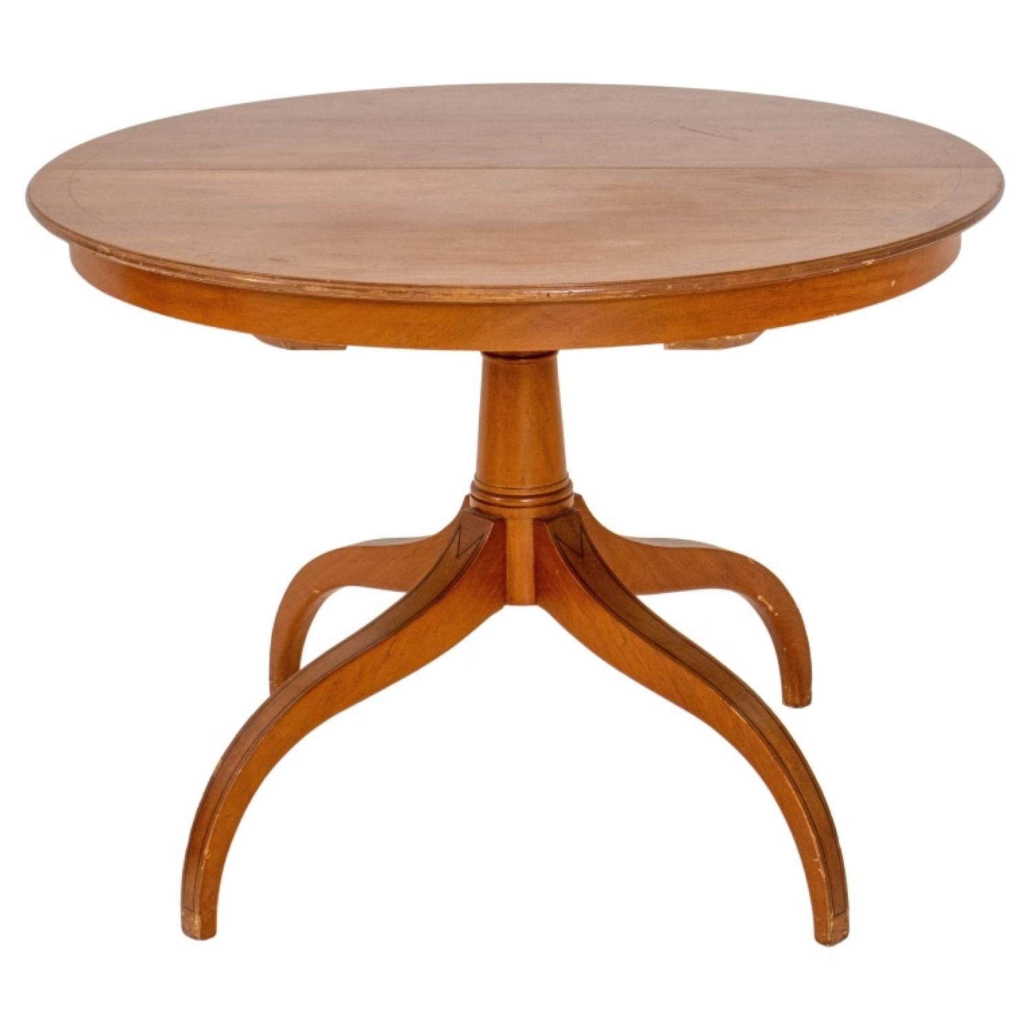 Circular extending mahogany dining table, the round top with ebonized stringing, above a quadrupedal pedestal base similarly stringed and with two rectangular leaves.

29 inches in height, 40 inches in diameter, with two leaves each 40 inches in