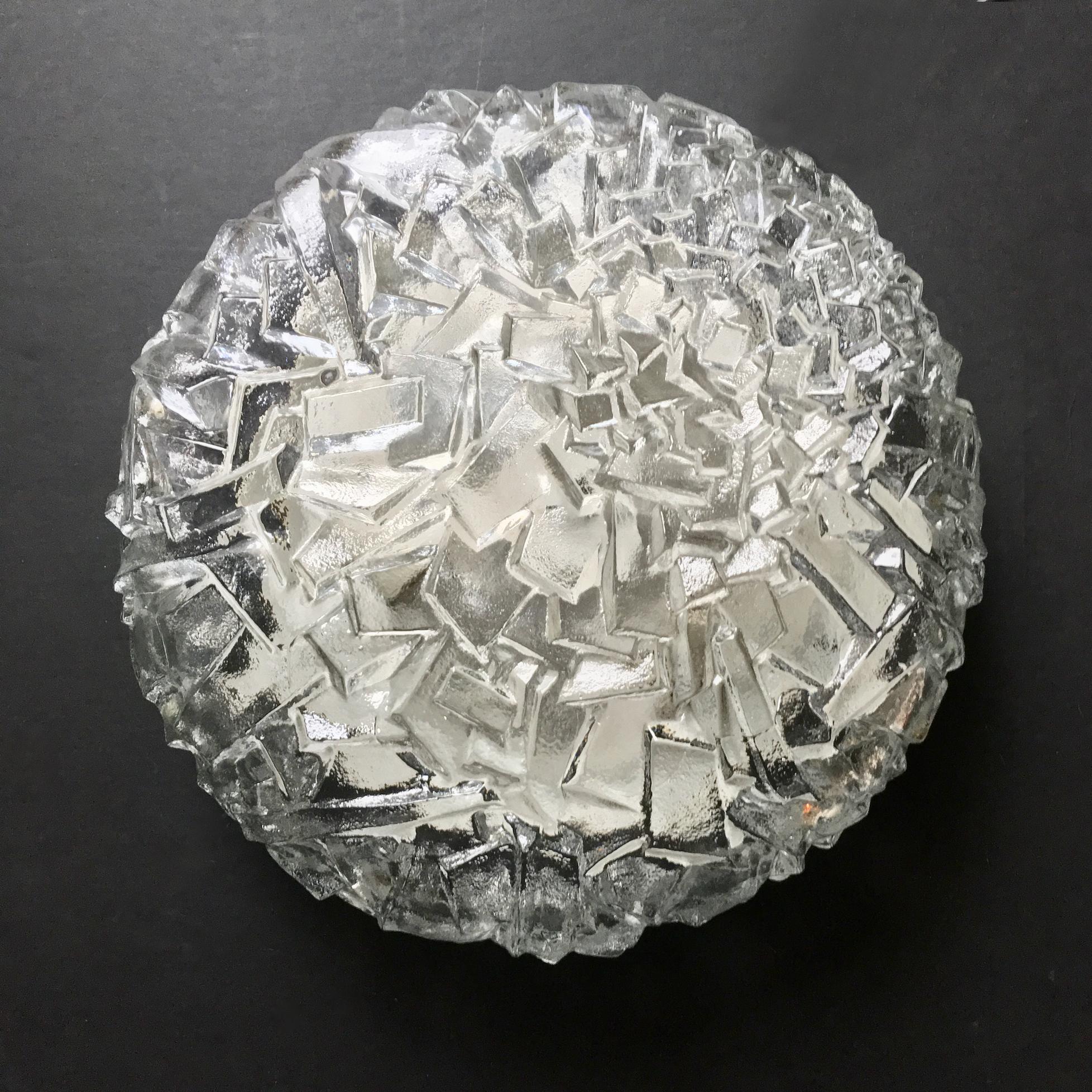 Large circular glass flush mount light with ice block pattern by Kaiser Leuchten, Germany, 1970s. 

The heavy shade comprises a single piece of thick clear glass folded around a white metal frame, held in place with three steel screws as shown. An