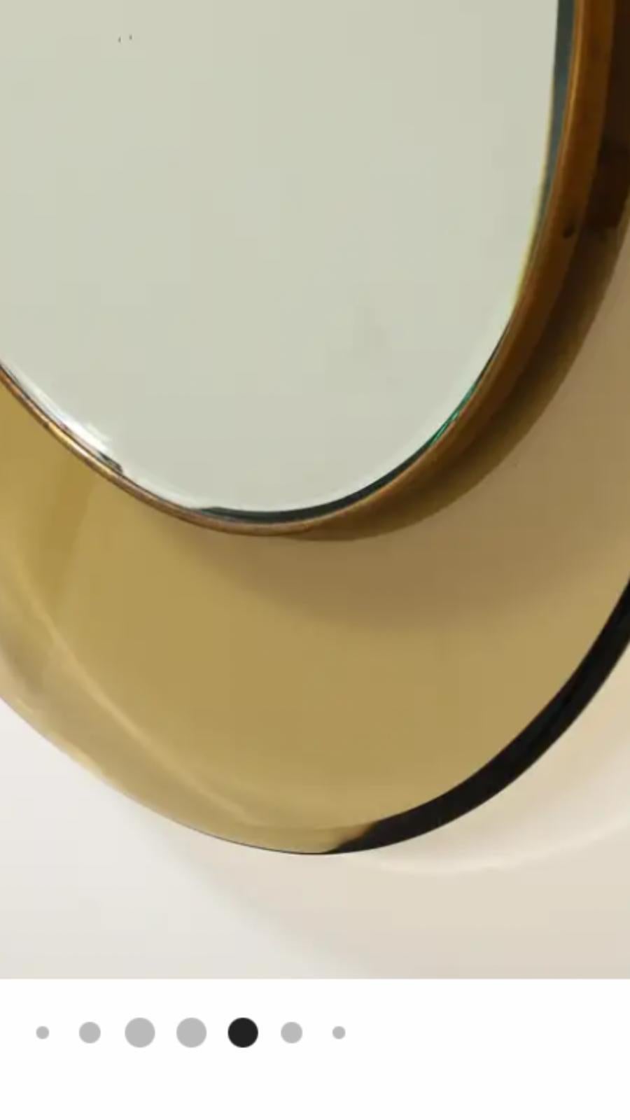 Un miroir circulaire en verre concave Mod. 1669 miroir circulaire en verre concave conçu par Max Ingrand pour Fontana Arte, vers 1960. Ce magnifique exemple de verre de couleur brun clair/jaune foncé est entouré de laiton chromé et de verre miroir