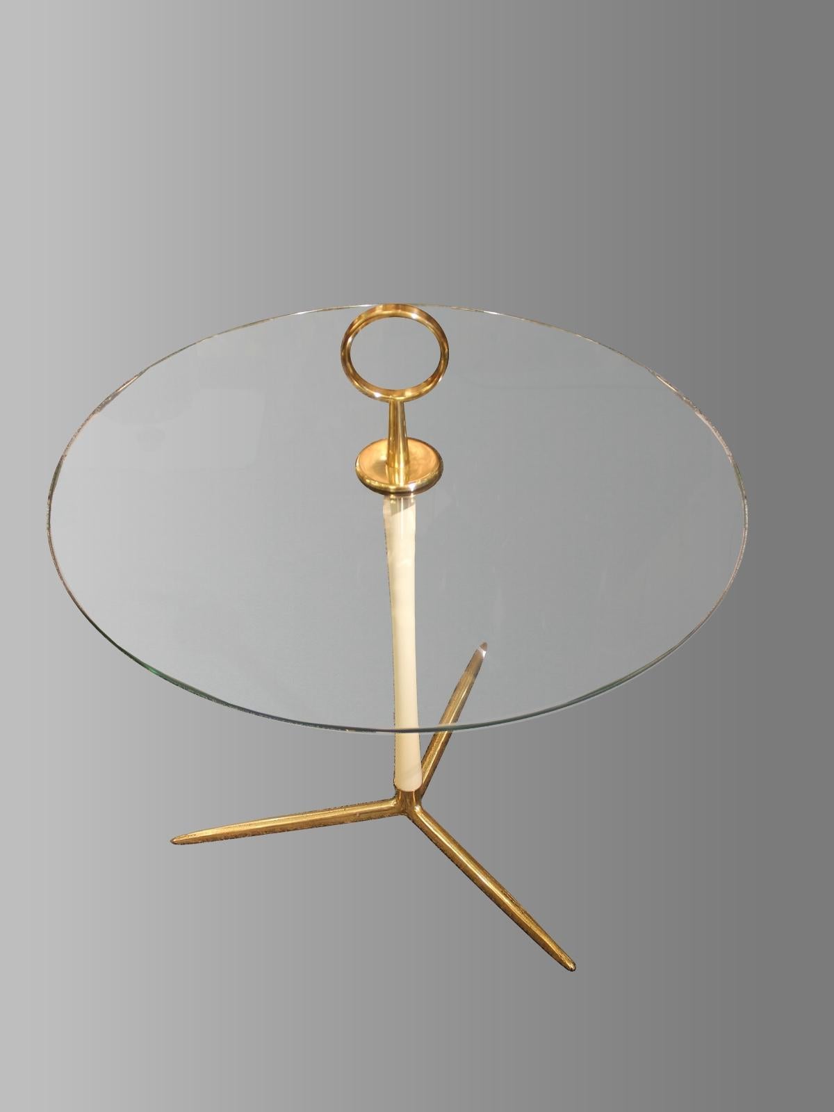 Circular pedestal table with handle
Italian work, circa 1950
Brass, off-white lacquered metal, glass.

Measures: Height 24.8 in
Platform height 18.5 in
Diameter 23.6 in.