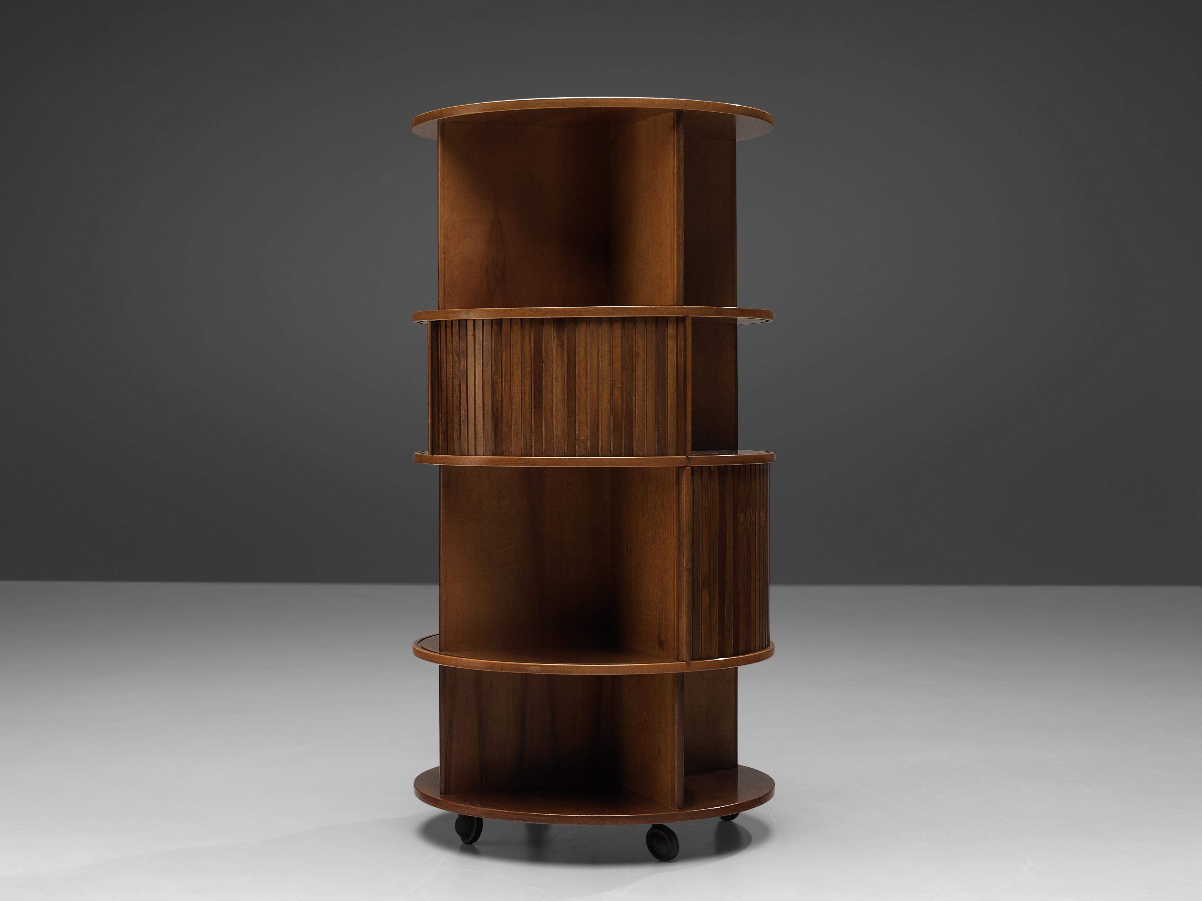 Movable circular cabinet, walnut, metal, Italy, 1950s

Free-standing cabinet or bookcase in circular shape. It rests on wheels, so that it can be moved around flexible in the room. Four levels of open shelves allow you to showcase your chosen