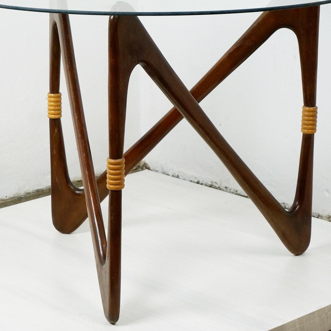 Dieser sehr elegante runde Midcentury Modern Couchtisch wurde in den 1950er Jahren von Cesare Lacca in Italien entworfen und hergestellt. Er verfügt über einen organischen Holzsockel mit einer runden Glasplatte, ist in sehr gutem Zustand und