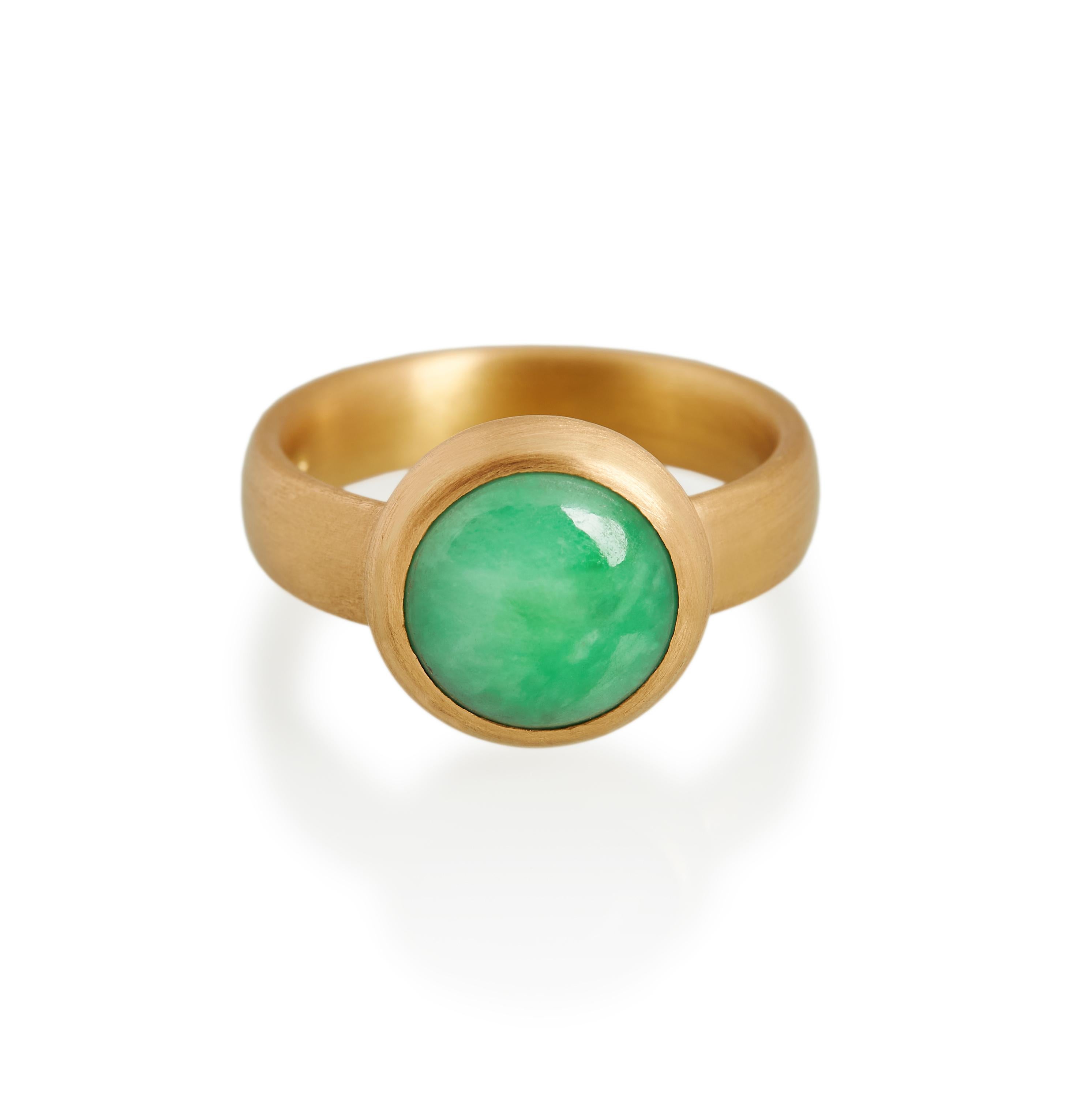 Circular cabochon cut natural antique jade ring. This exquisite vivid green jade is set in matte finished hand carved 22ct gold with a domed back to the setting. 
Ref: G20004

12mm round natural jade 
22ct gold

Cadby & Co are a family business that