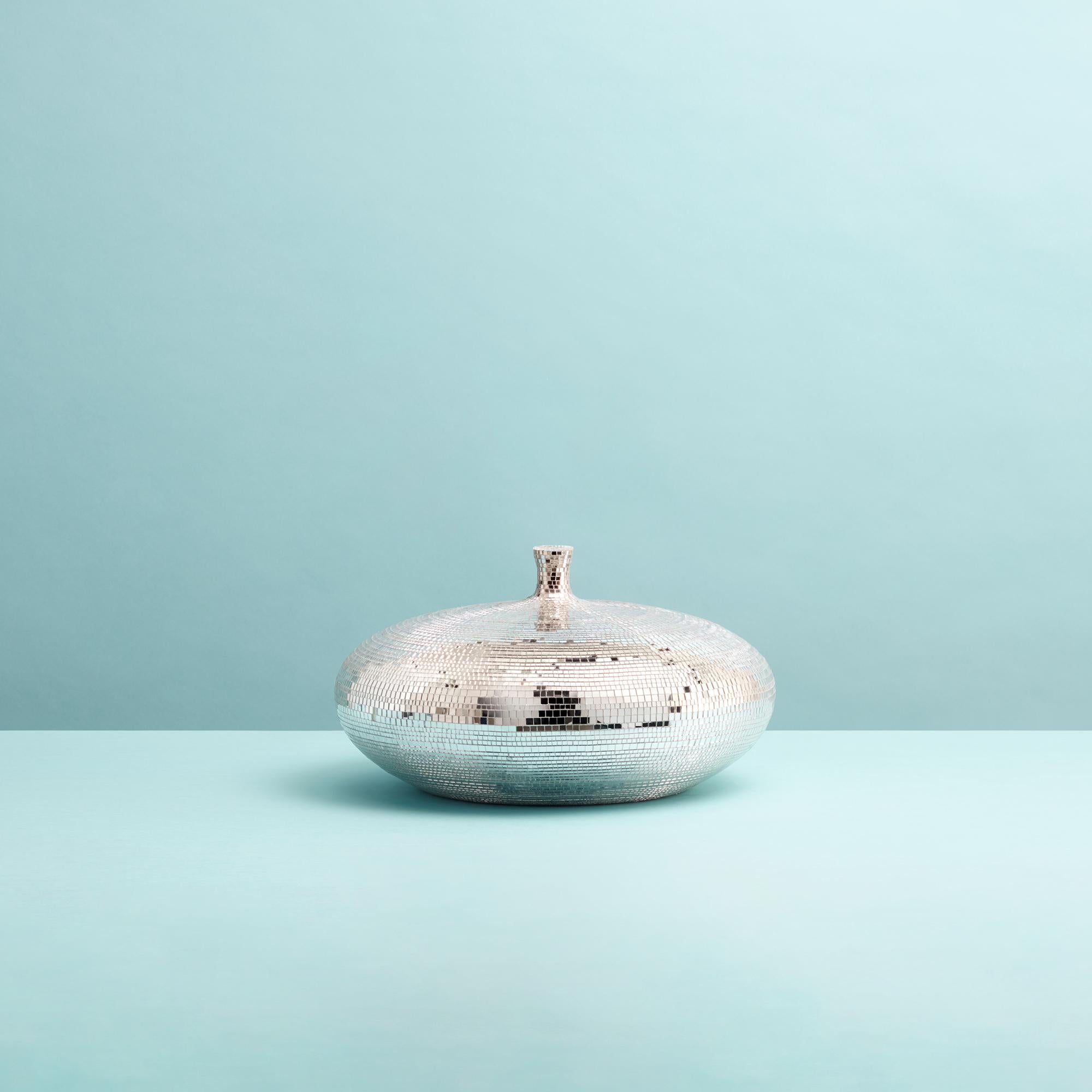 Exuding glamour from every angle, this harmonious bowl with a convex lid is sure to enliven any console or vanity with its stylish look. Perfect for storing beauty essentials, the design is best showcased alongside a table lamp, its delicate light