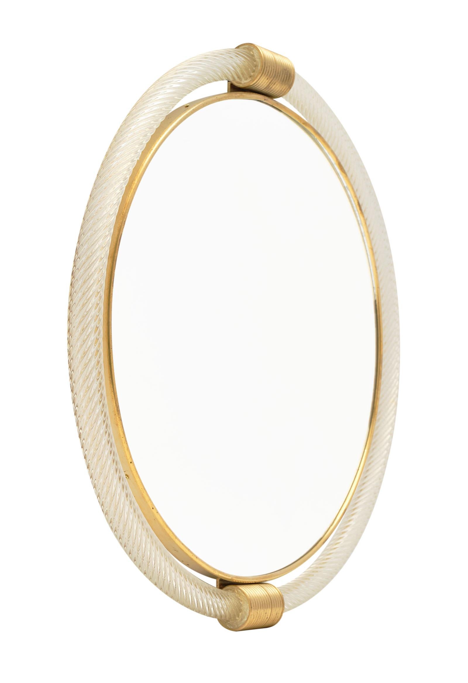 Circular Murano glass “torsado” mirror by Giuliano Fuga. We love the brass framed circular glass mirror surrounded by hand blown “torsado” glass with 23-carat gold fused within. A striking mirror!