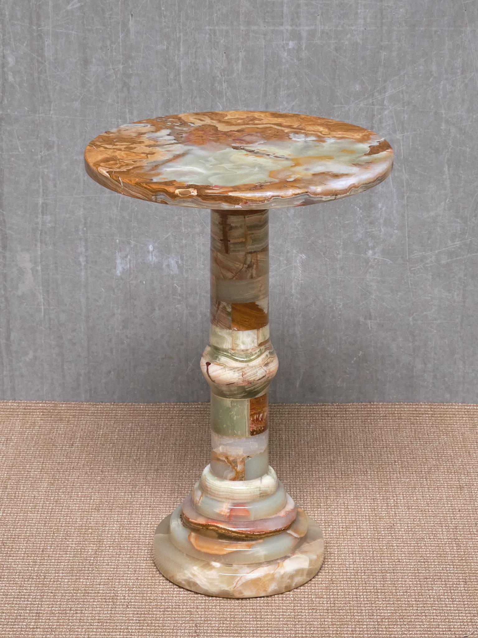 This elegant side table was produced in Italy in the 1960s. The pedestal base is composed of circular stacked discs and sections of solid onyx, creating a beautiful pattern and mosaic effect throughout. The round top is also made of multicolored
