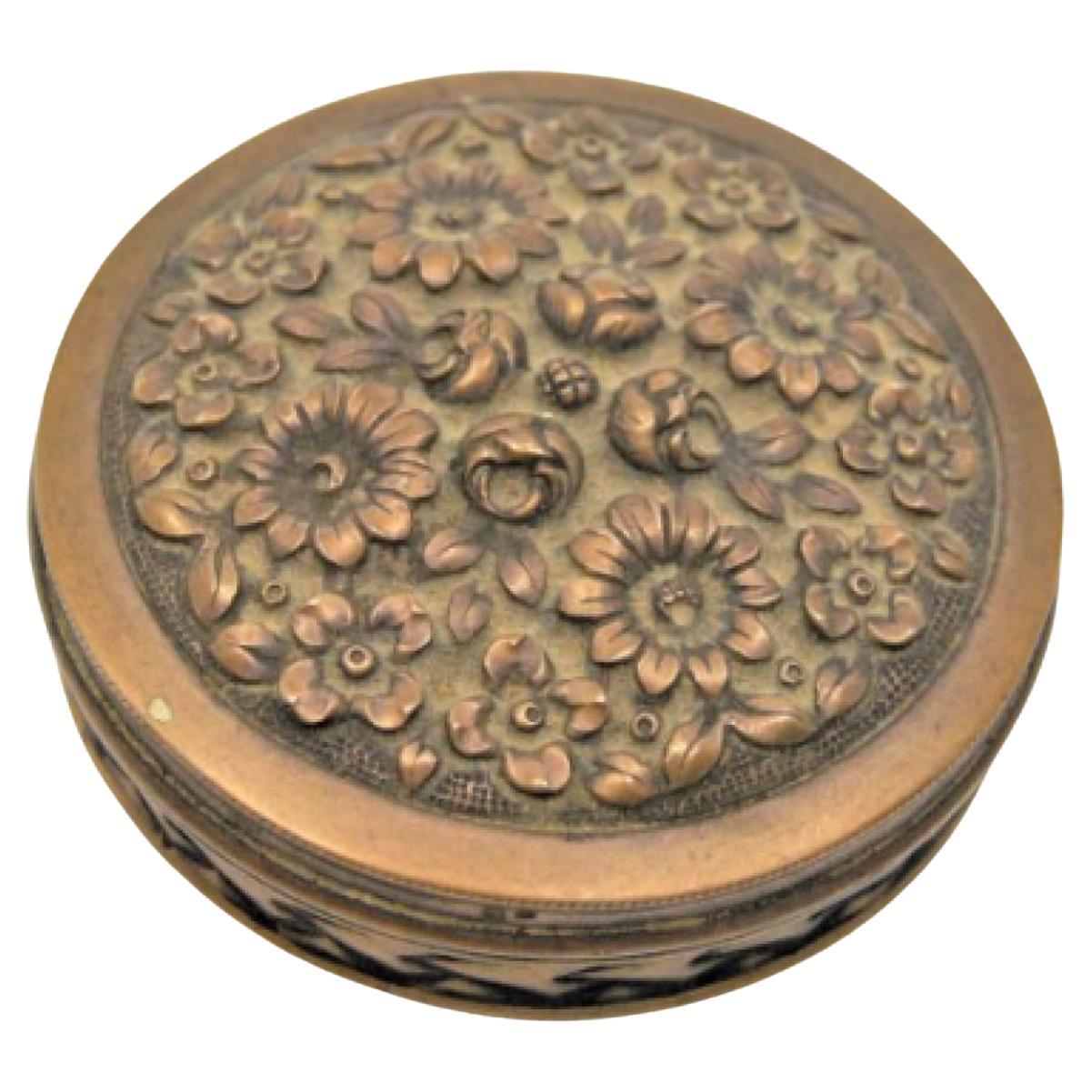 Circular pill box with engraved plant motifs