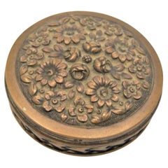 Circular pill box with engraved plant motifs