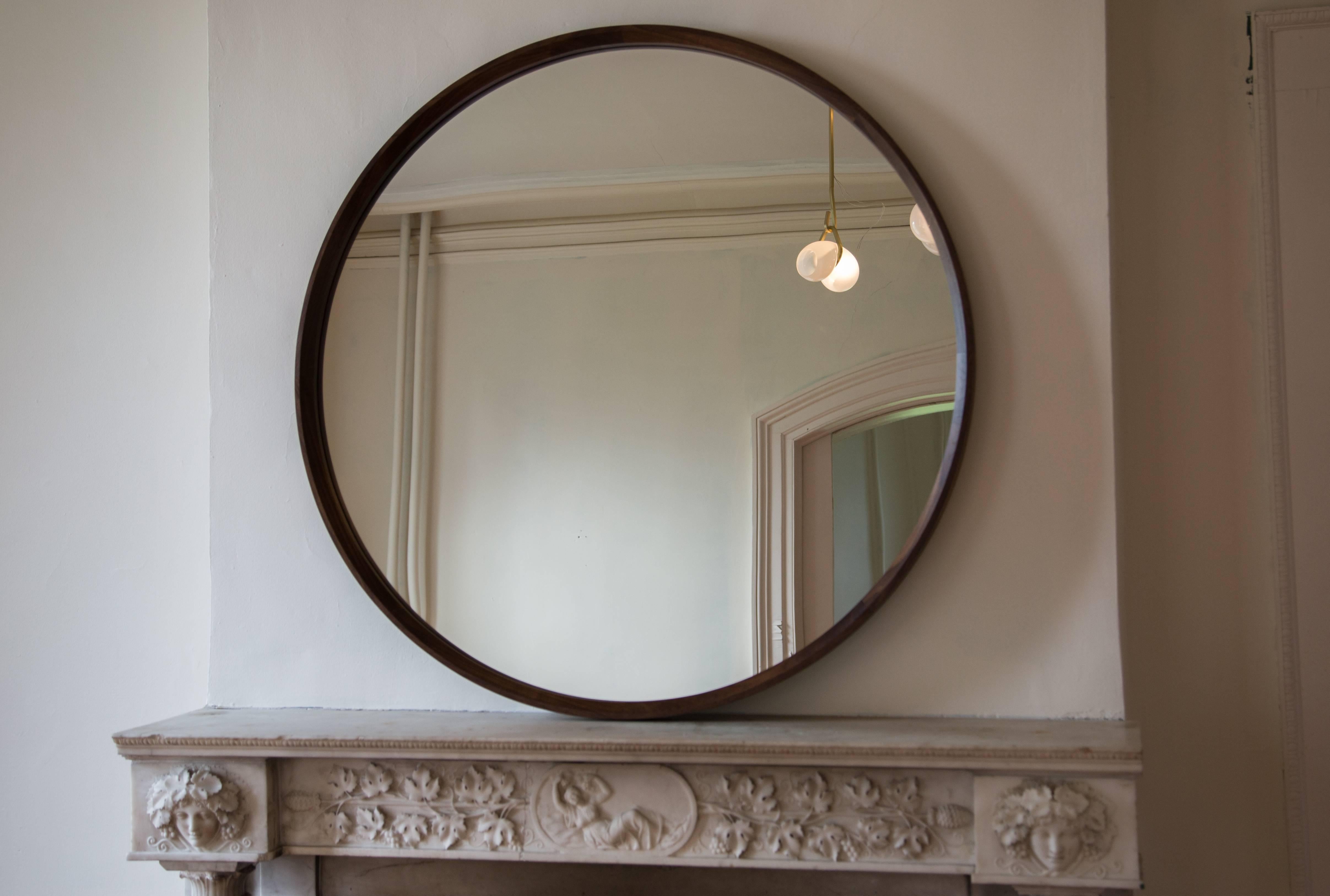 This simple, elegant mirror features a large interior bevel around the wooden frame creating a beautiful thin outer rim. Walnut frame shown in circular wall mounted version and rectangular full-length floor version.

Made to order in custom sizes,