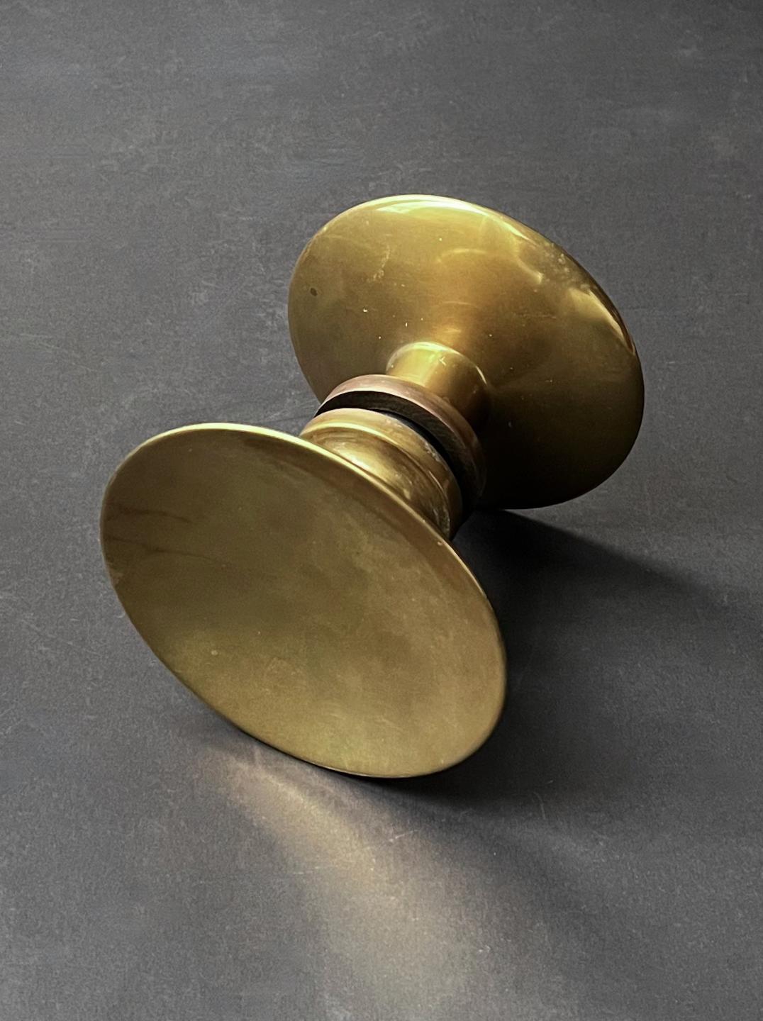 Circular push-and-pull door handle in bronze, mid-20th century, France.

A simple elegant handle, made up of two separate round pieces; each side with a slightly concave dish and wide stem. The components are in good vintage condition with signs of