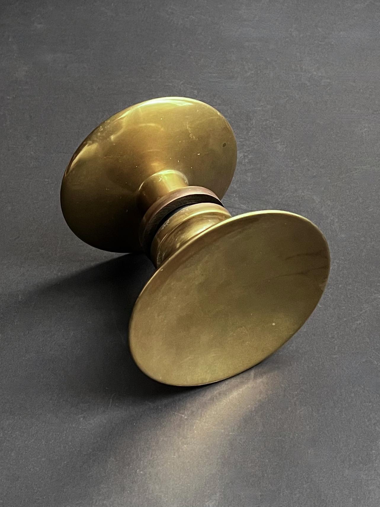 Circular push-and-pull door handle in bronze, mid-20th century, France.

A simple elegant handle, made up of two separate round pieces; each side with a slightly concave dish and wide stem. The components are in good vintage condition with signs of