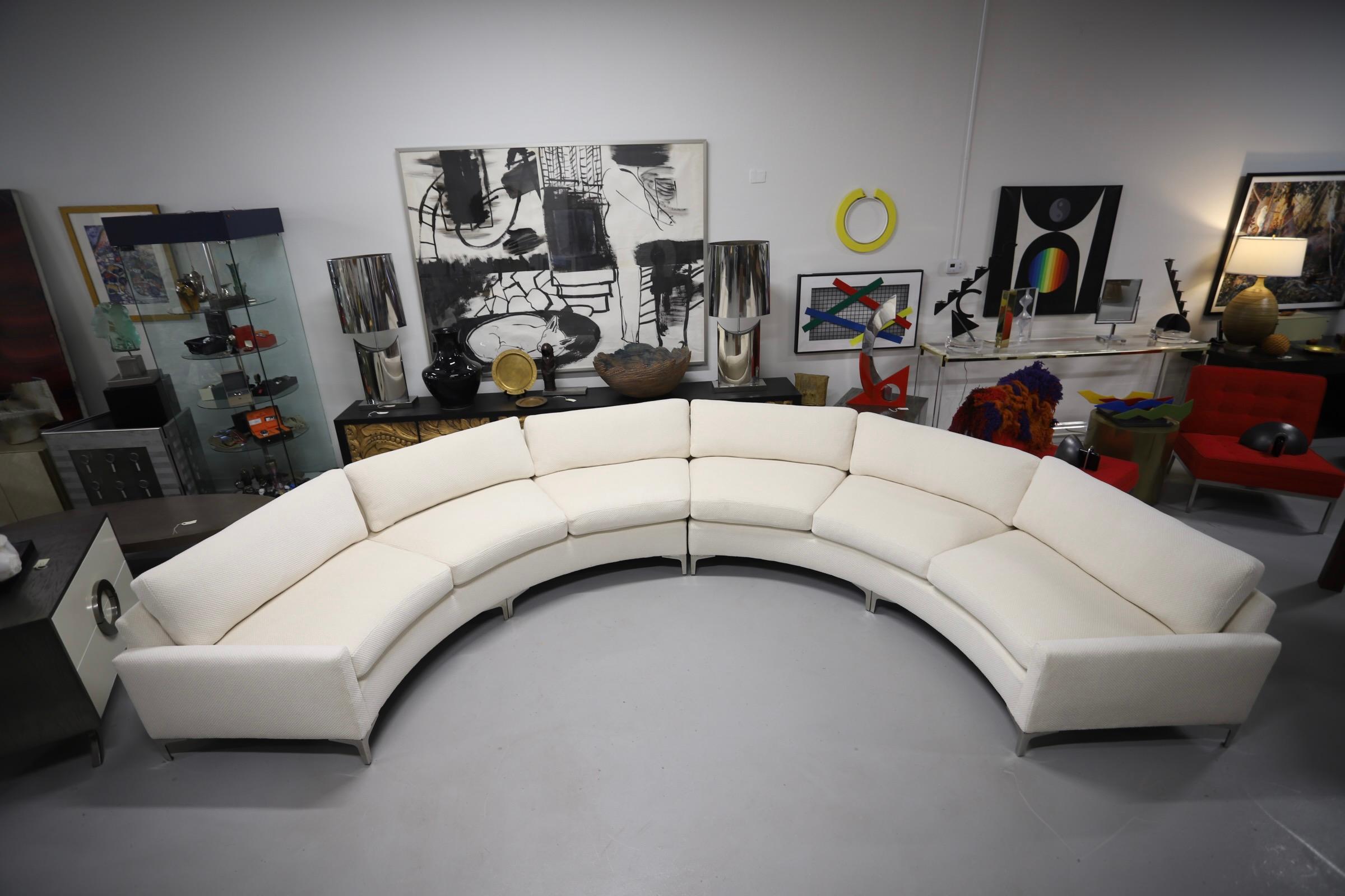 A large half circle sofa completely re-upholstered in a lovely Holly Hunt fabric. There are 2 sections. Streamlined metal legs. This sofa dates to the 1980s. It had a floral pattern on it from the estate it was purchased from. It is quite large