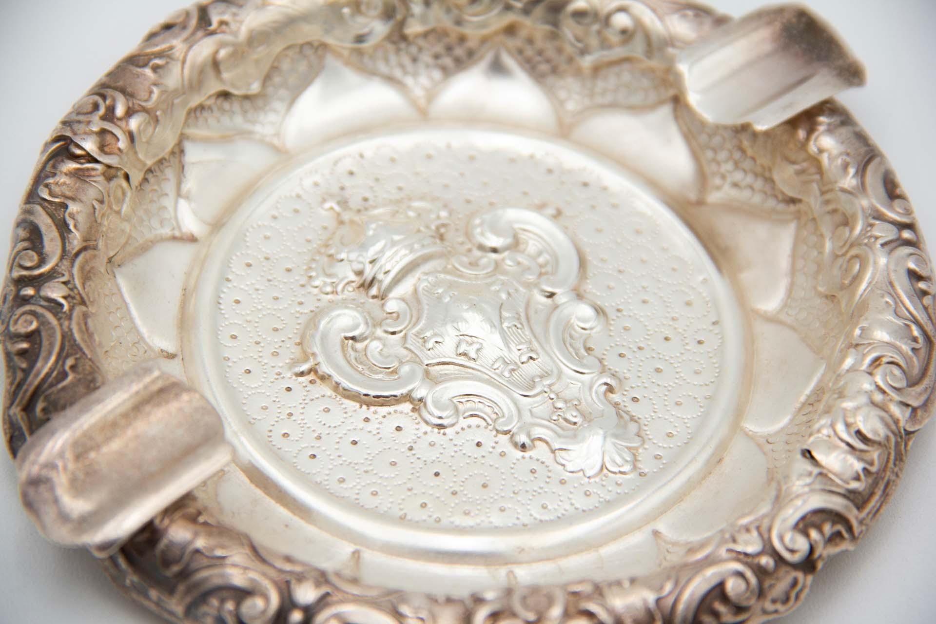 Description : Cendrier circulaire en argent avec les armoiries portugaises en relief au centre. Métal : Argent. Origine : Portugais. Poinçon : aigle debout. Poids : 86,16 grammes. Dimensions : 12,6 cm x 1,6 cm : 12.6cmx1.6cm. Contenu : 833/1000.