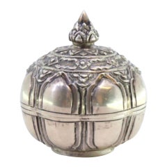 Circular silver box with embossed fruit and knob on the lid