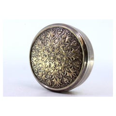 Circular silver box with floral reliefs on the removable lid
