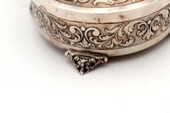 Circular silver box with reliefs and monogram card