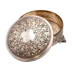 Circular silver box with reliefs and monogram card