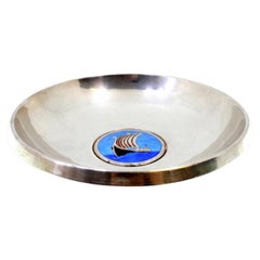 Circular silver cup with a Viking ship enamel frame in the center