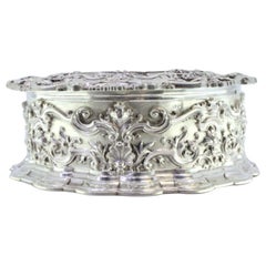 Circular silver jewelry box with shells, scrolls and ancient-lady figure Circular silver jewelry box with shells, scrolls and ancient-lady figure