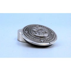 Circular silver pill box with a guardian angel on the removable lid
