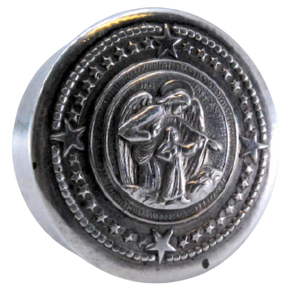 Circular silver pill box with a guardian angel on the removable lid