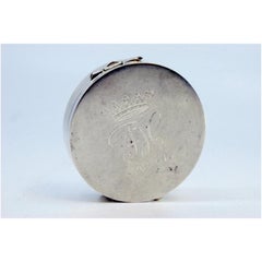 Circular silver pill box with engraving on the hinged lid