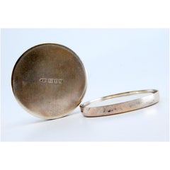 Runde Pillendose aus Silber mit goldfarbenen Blumenmotiven auf dem abnehmbaren Deckel