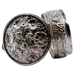Circular silver pill box with relief plant motifs and hinged lid