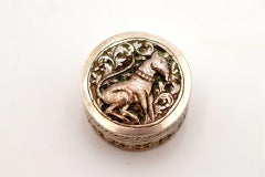 Circular silver rosary box with embossed dog figure