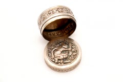 Circular silver rosary box with embossed dog figure