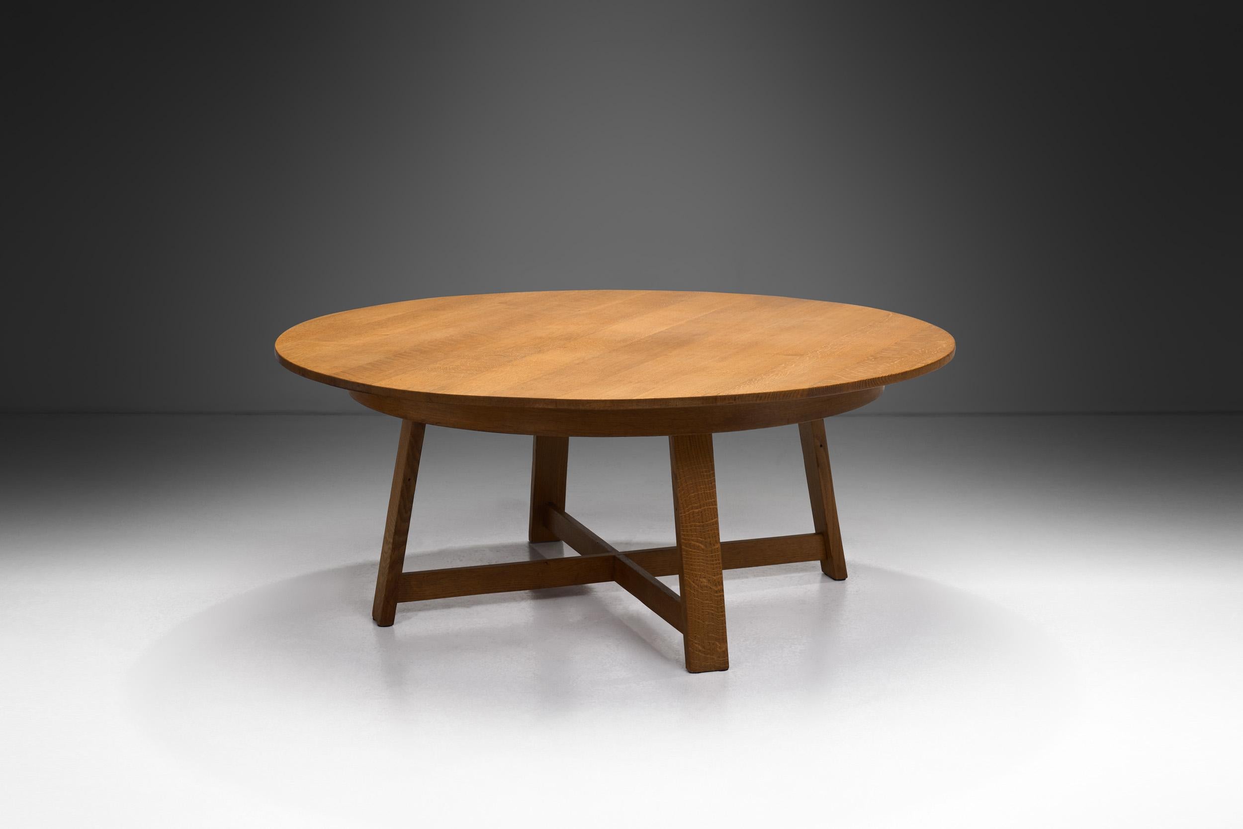 This circular table embodies the essence of European mid-century design with its distinct features that harken back to a time when form and function were paramount. Crafted from solid wood, this table exudes a rustic charm and robust aesthetic that
