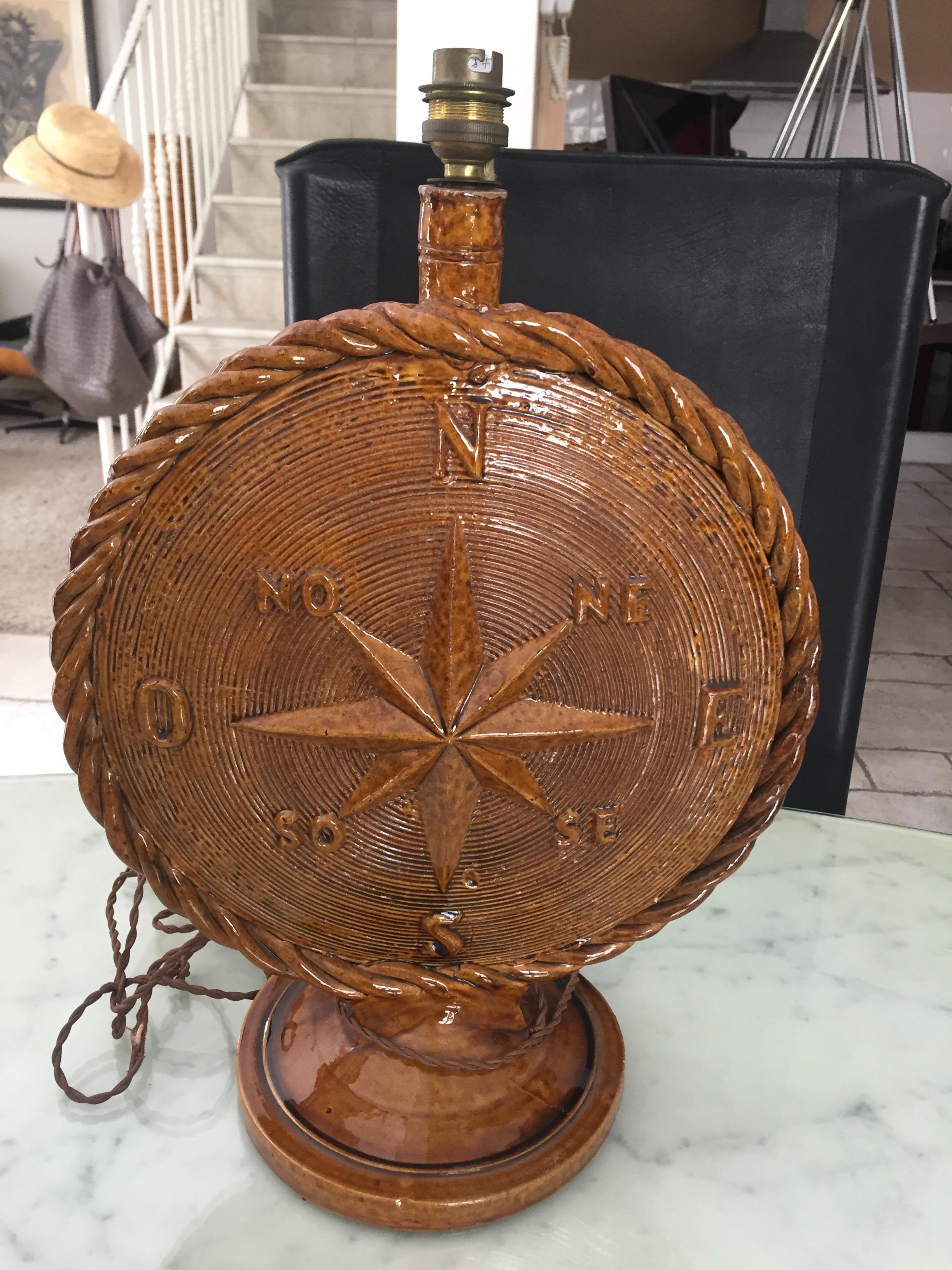 Atelier Cerenne Vallauris, 1950.
Large 42 cm round lamp in brown enameled earthenware decorated with a wind rose on one side and an anchor and rope on the other. The edge decor of rope. signed.
 