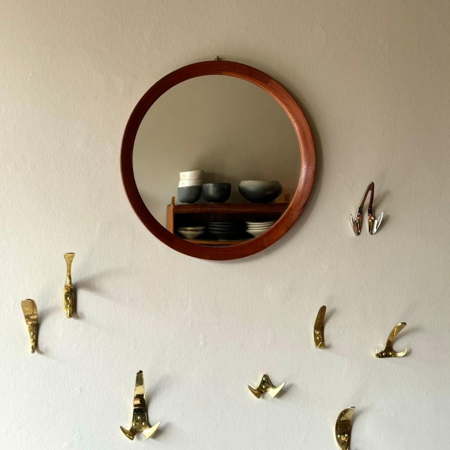 A circular teak wall mirror, made in Denmark during the 1950s.

The slim, circular teak frame of this mid-century wall mirror would make a subtle statement in any space. A mirror large enough to be placed over a dressing table, or placed simply to