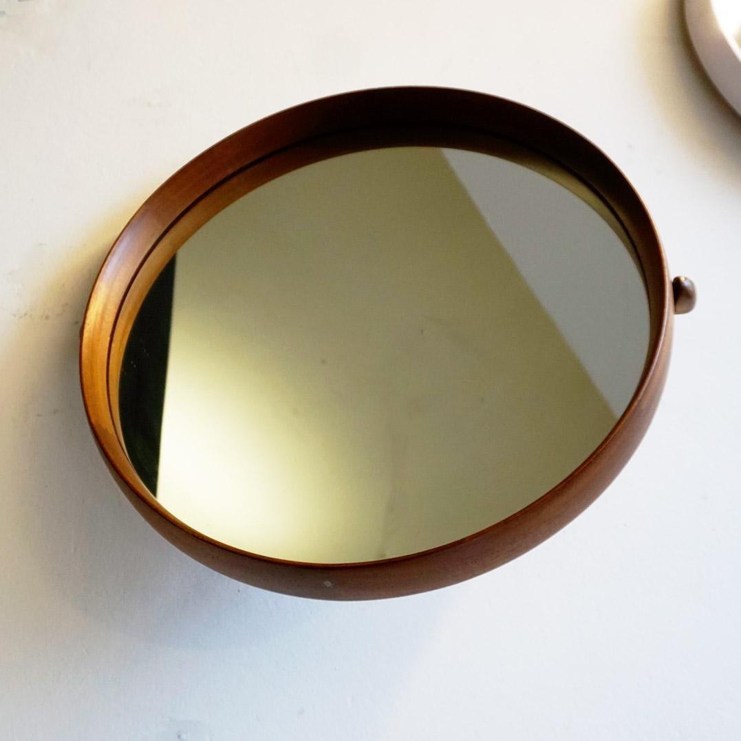 This amazing Scandinavian Modern adjustable circular  teak wall mirror can be attributed to Uno and Osten Kristiansson and manufactured by Luxus Vittsjö Sweden in the 1960s as it is marked on the reverse Vittsjömöbel and made in sweden. 
The mirreor