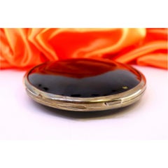 Circular tortoiseshell box with silver trim, hinged lid and spring closure