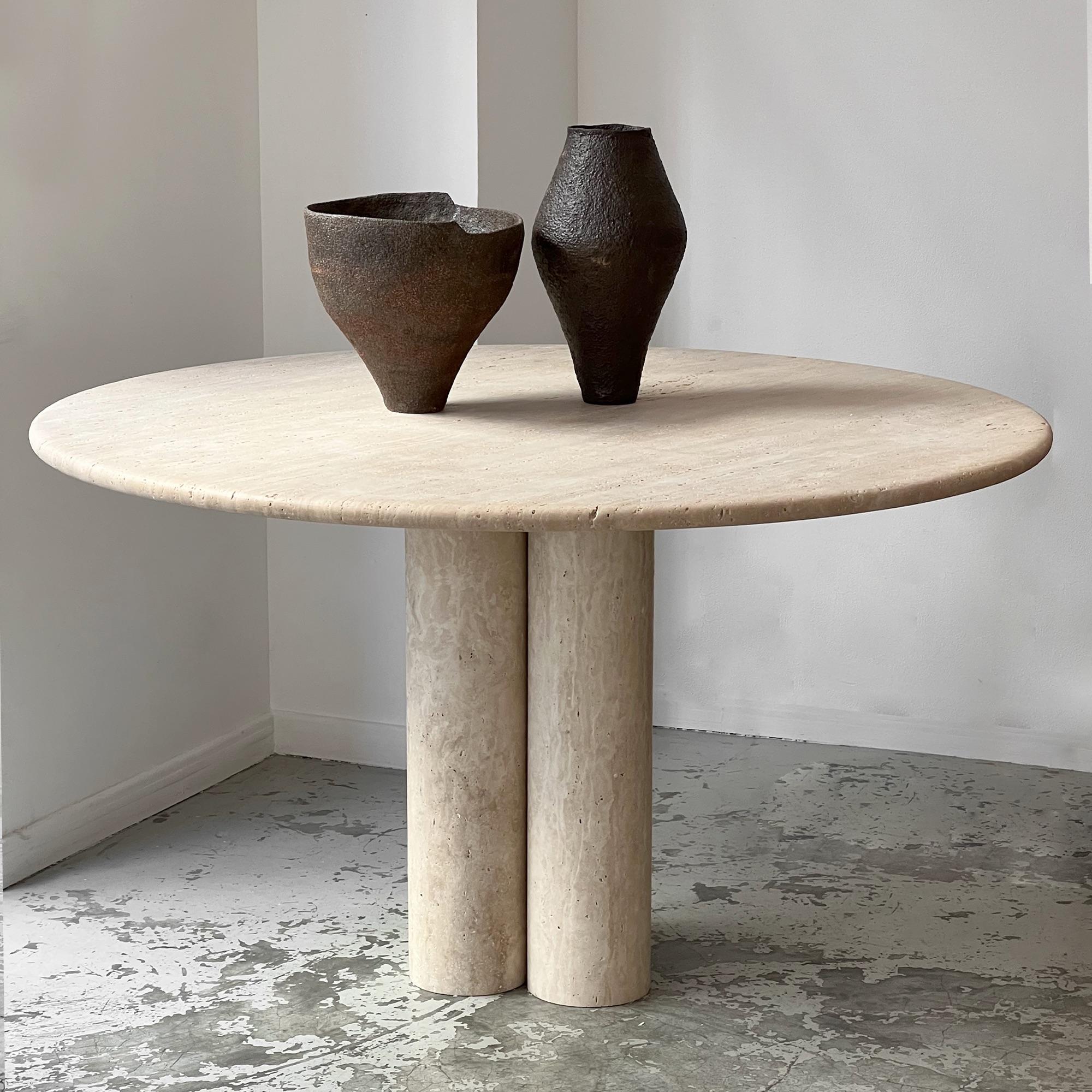 Untreated natural travertine table. The overall structure is in travertine. The top is circular and rests directly on three solid cylinders forming the base.
In very good condition.