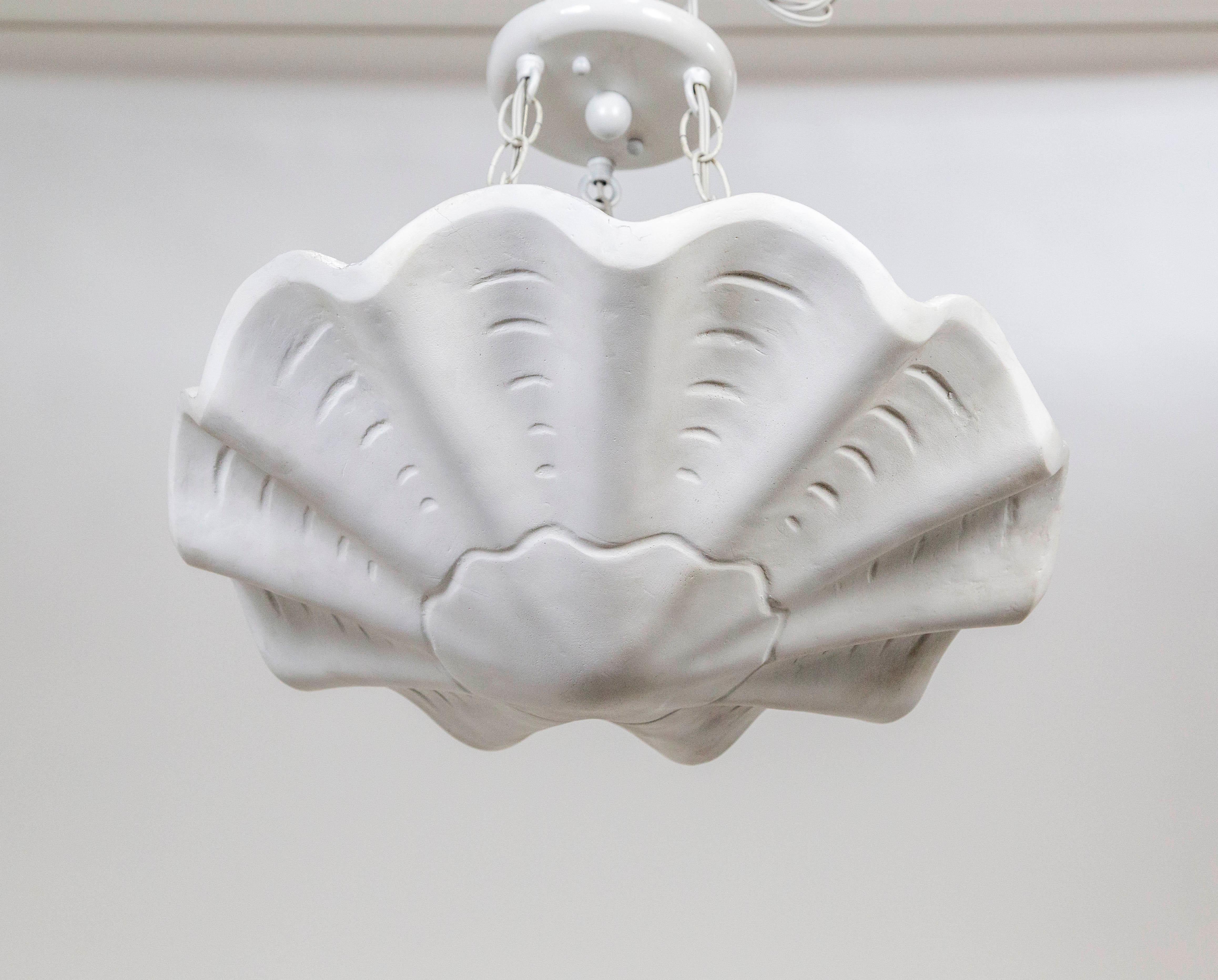 A plaster pendant in an undulating shell shape, with scalloped edges and imprinted lines accentuating the form.  A newer take on Francis Elkins's 1940's plaster plafonnier.  Hanging by three white chains; with 3 medium base ceramic sockets.