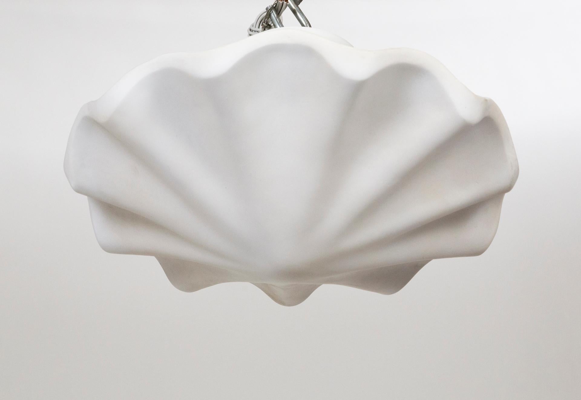 A plaster pendant in a smooth, undulating shell shape, with scalloped edges.  A newer take on Francis Elkins's 1940's plaster plafonnier.  Hanging by three white chains; with 3 medium base ceramic sockets. Contemporary; made from an original mold.