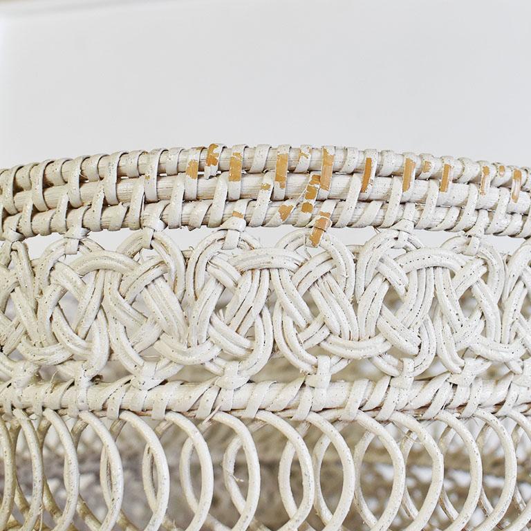 Circular white woven wicker basket. This piece features a woven wicker bottom and a woven floral knot pattern top. Use it as a planter, or as a wastebasket. 

Dimensions:
10.25