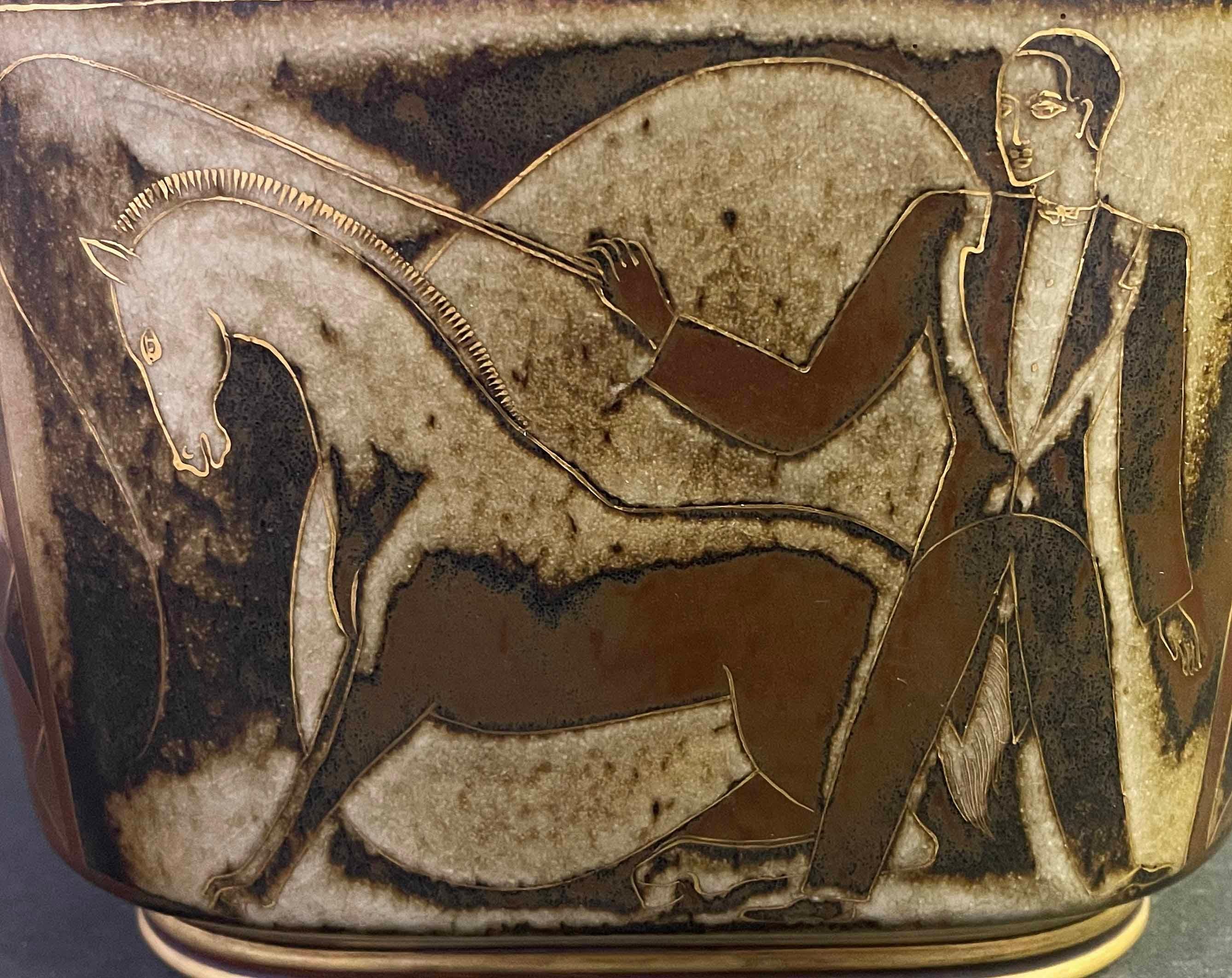 Although this unique covered urn captures circus scenes that are decidedly populist in nature, this piece is highly sophisticated and emphatically Art Deco.  Note the repeated geometric motifs at each corner, and the gold-edged star atop the lid. 
