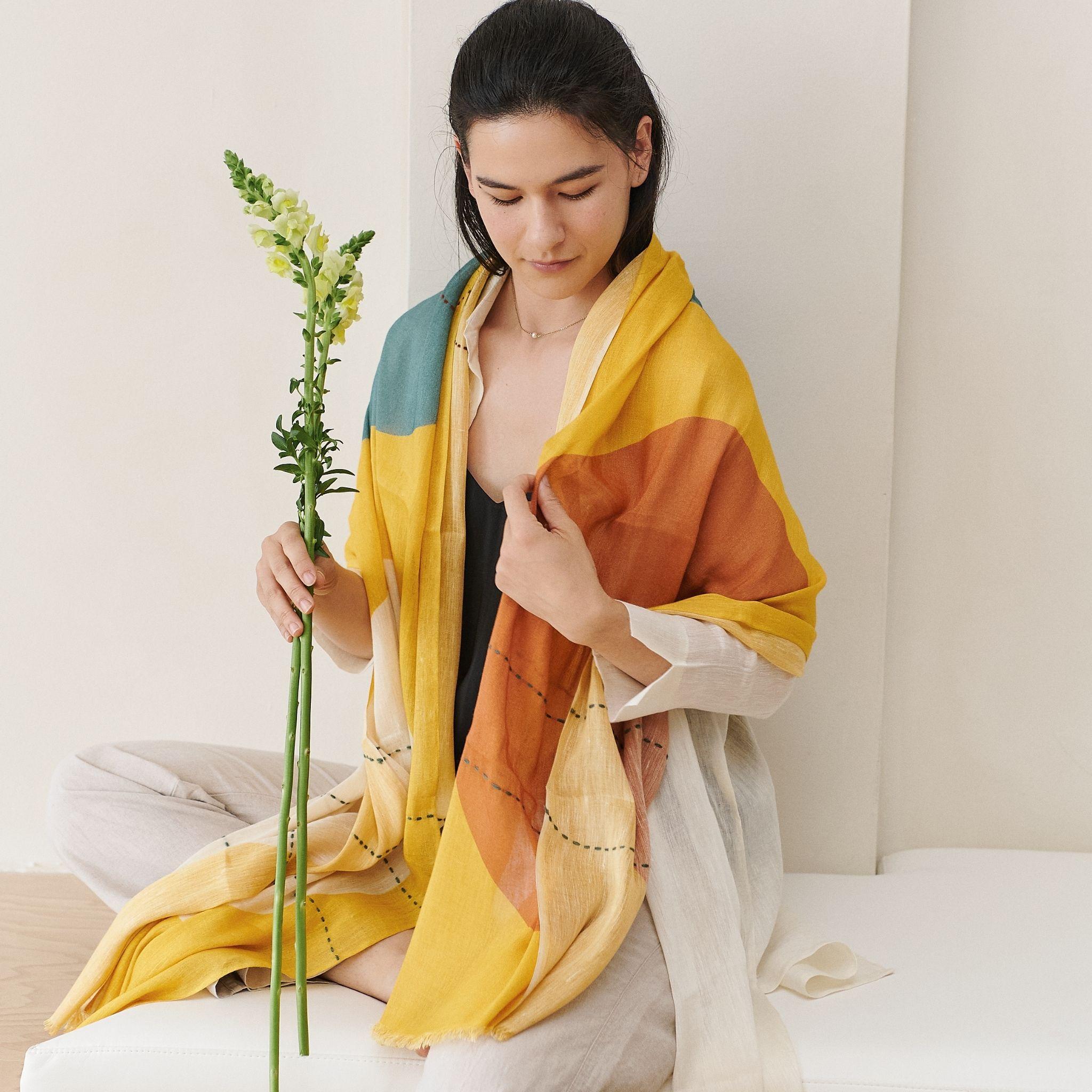 Une tranche de soleil associée à un imprimé contemporain et à une broderie à la main superposée, voilà ce qu'est l'écharpe solaire Cirq. Ce foulard intemporel est tissé à la main par des tisserands du Népal avec lesquels nous collaborons