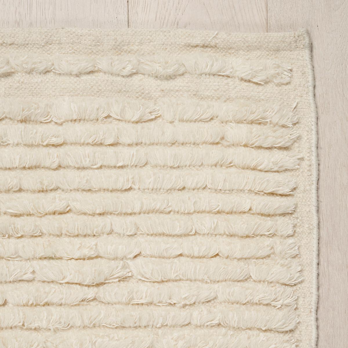 Unser Teppich Cirrus ist ein einfaches Flachgewebe aus Wolle, das durch pelzige Reihen von fransenähnlichen Baumwoll-Leinen-Tuftings auffällt. Dieser einzigartige Teppich ist ein unaufdringliches Statement und verleiht jedem Raum eine luxuriöse