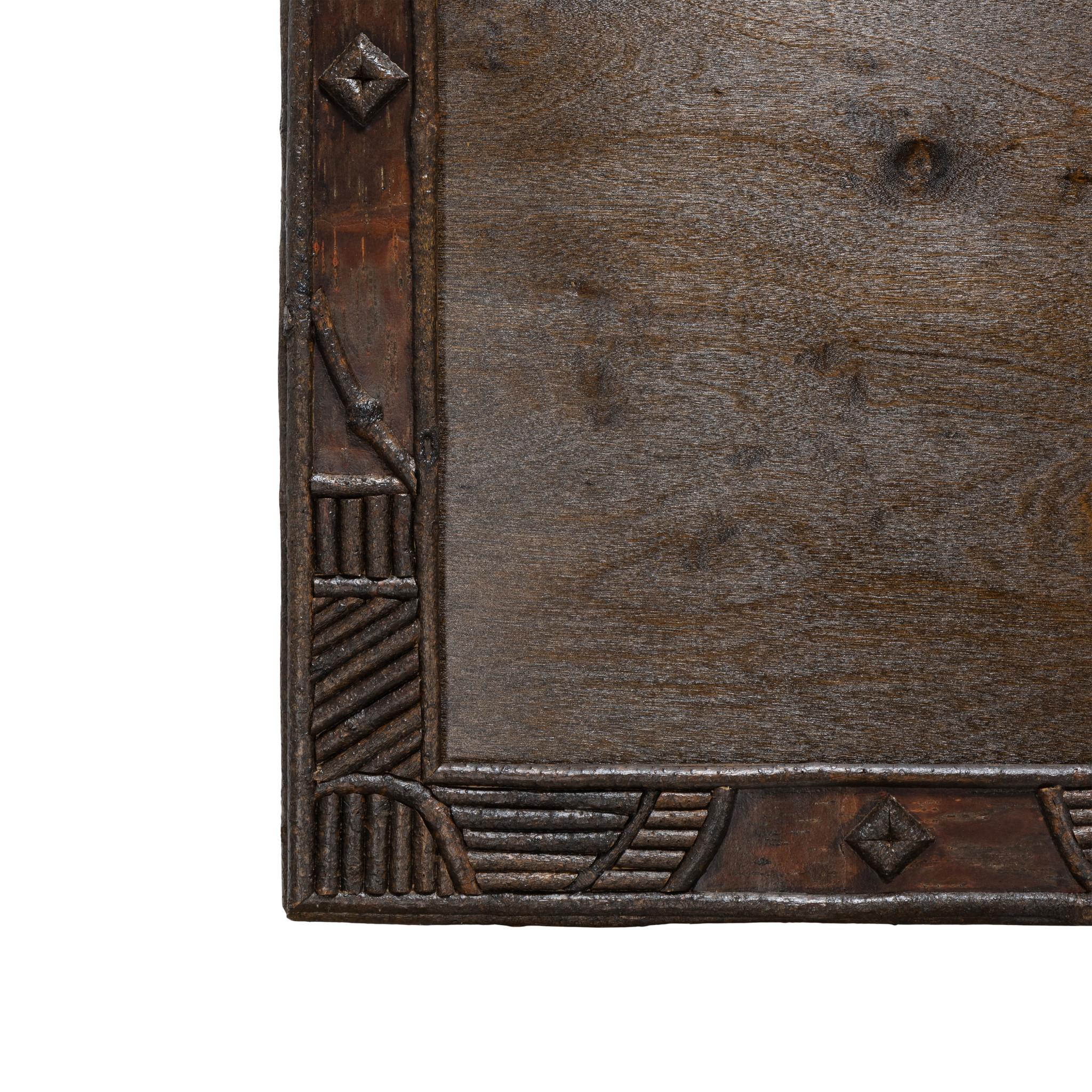 Cisco's Adirondack beveled mirror with twig work frame and crowned top having center burl. Wood detailing is intricate with rounded and stacked sticks and diamond shapes. All stained a uniform dark brown color. Mirror 28