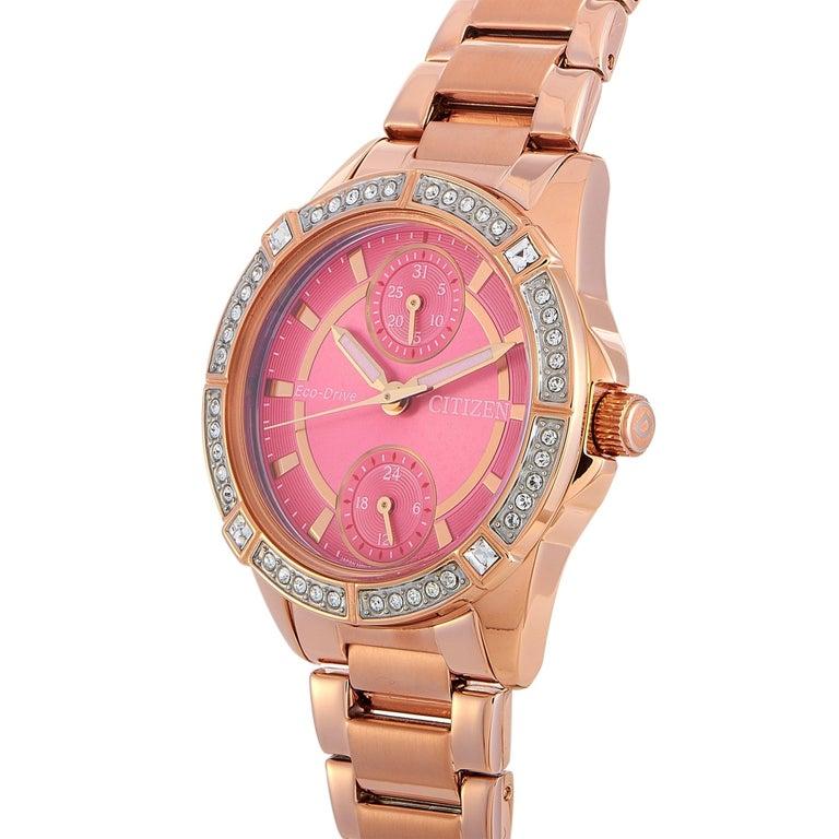 This is the Citizen Drive Eco-Drive watch, reference number FD3003-58X. It is presented with a water-resistant, rose gold-tone stainless steel case fitted with a bezel set with Swarovski crystals. The case measures 33 mm in diameter and is mounted