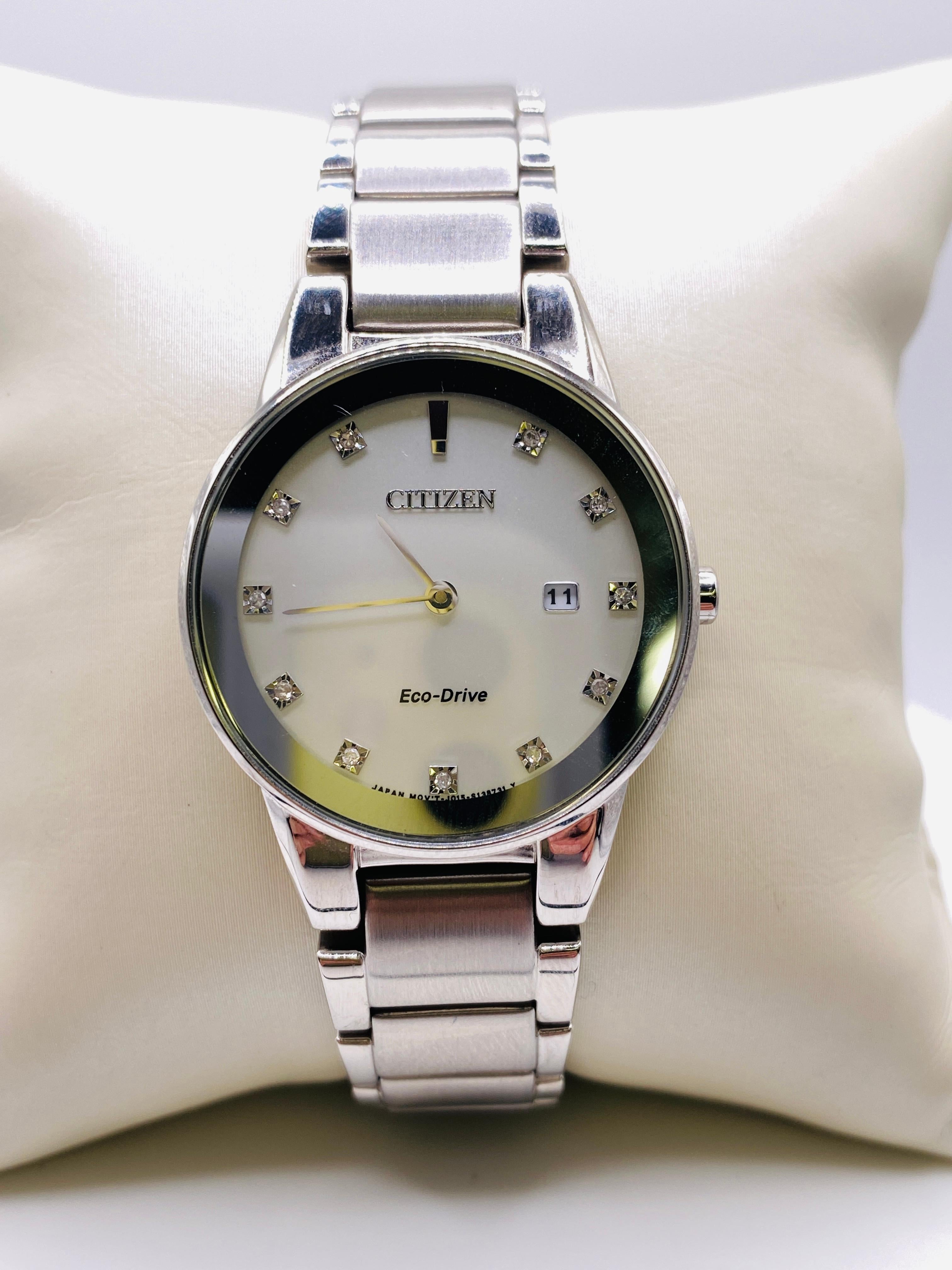 Citizen Eco Dirve Ladies Stainless Steel Watch with Crystal Dial Markers. Caliber J015, mineral crystal, silver dial, analog display, crystal on dial markers, date display, water resistant to 30m. Japanese Movement. Model J015-S095921, Serial