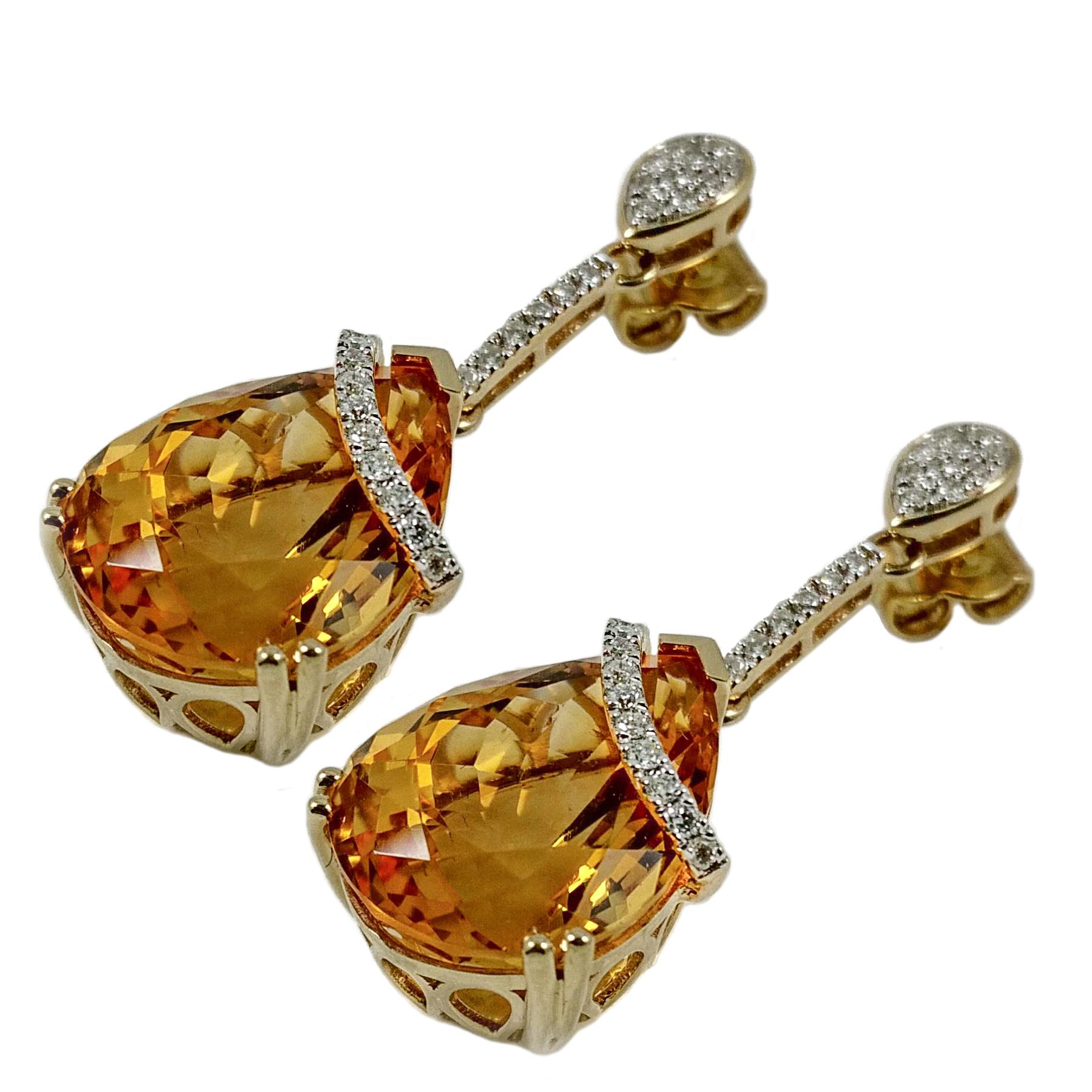 Elegant citrine diamond dangling earrings. Golden honey yellow, high luster, pear faceted 17.93 carats matching citrines, mounted in split prong and bead prongs, encased in basket mounting. Accented with round brilliant cut diamonds row across two