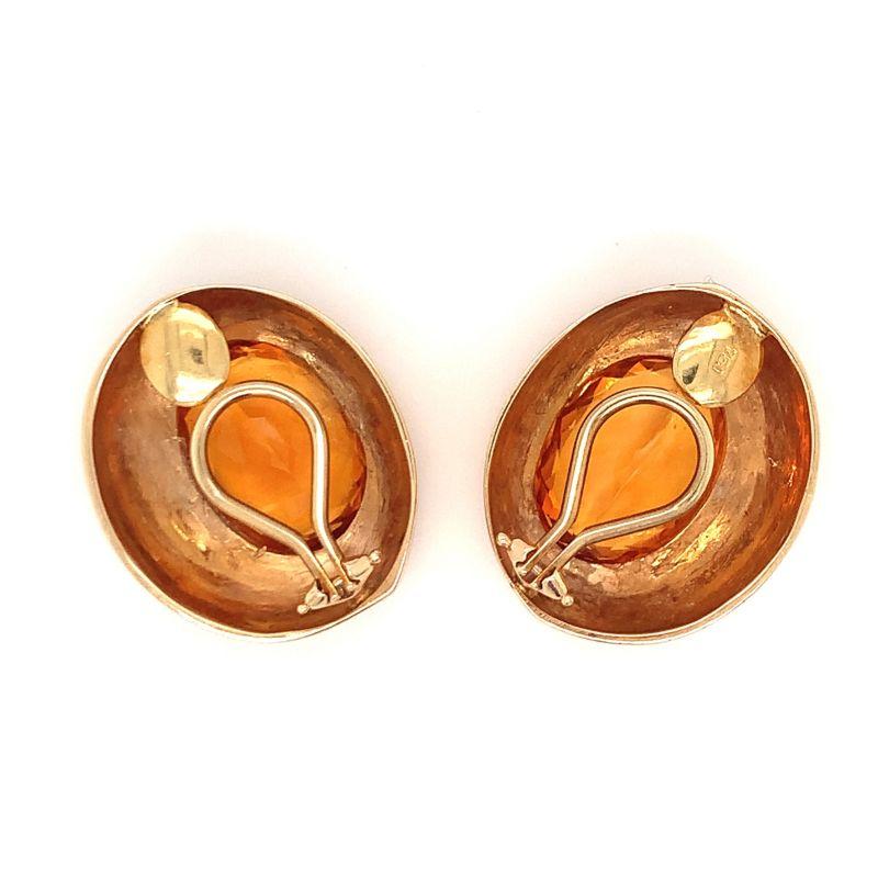 One pair of citrine 18K yellow gold earclips featuring two bezel set, oval mixed cut citrines totaling 20 ct. with geometric details and a high polish finish. Circa 1970s.

Pleasant, golden, luminous.

Additional information:
Metal: 18K yellow